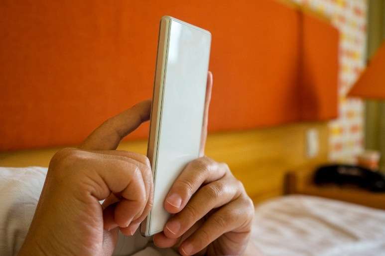 Man browsing sleeping apps in bed