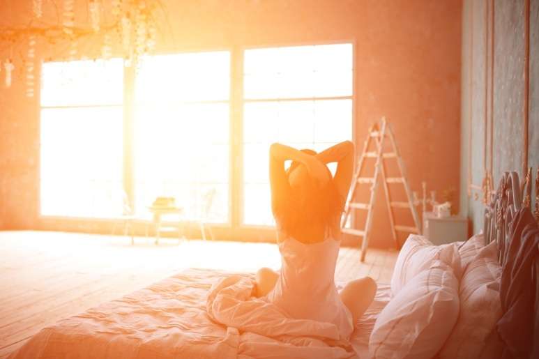 Woman stretching her back on the sofa bed