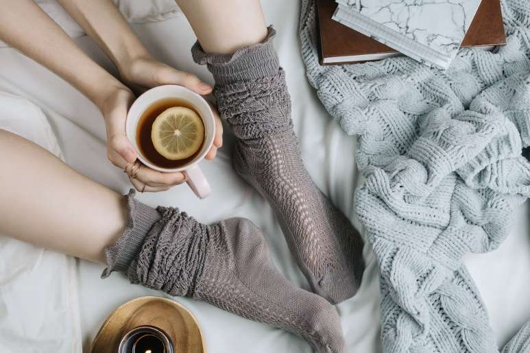 In bed with thick socks, tea, a fluffy throw blanket and a book