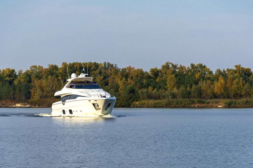 White luxury yacht in motion on the river in autumn
